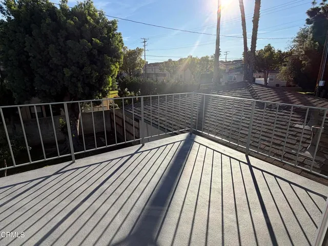 a view of balcony with wooden floor and fence