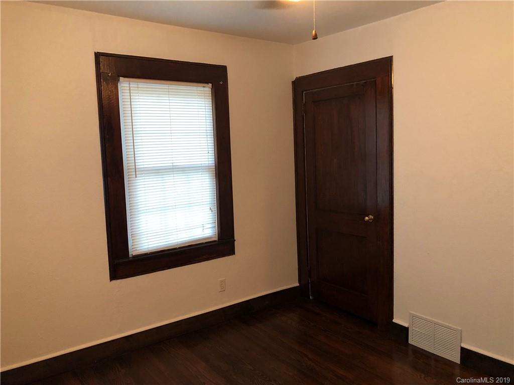726 Valleydale Road Charlotte, NC 28214 - Photo 14 of 32 an empty room with wooden floor closet and windows