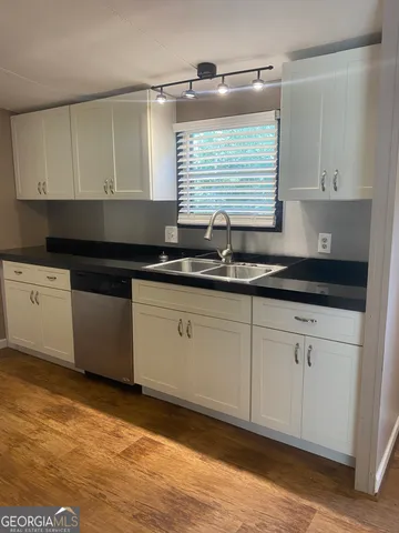 a kitchen with granite countertop white cabinets and stainless steel appliances