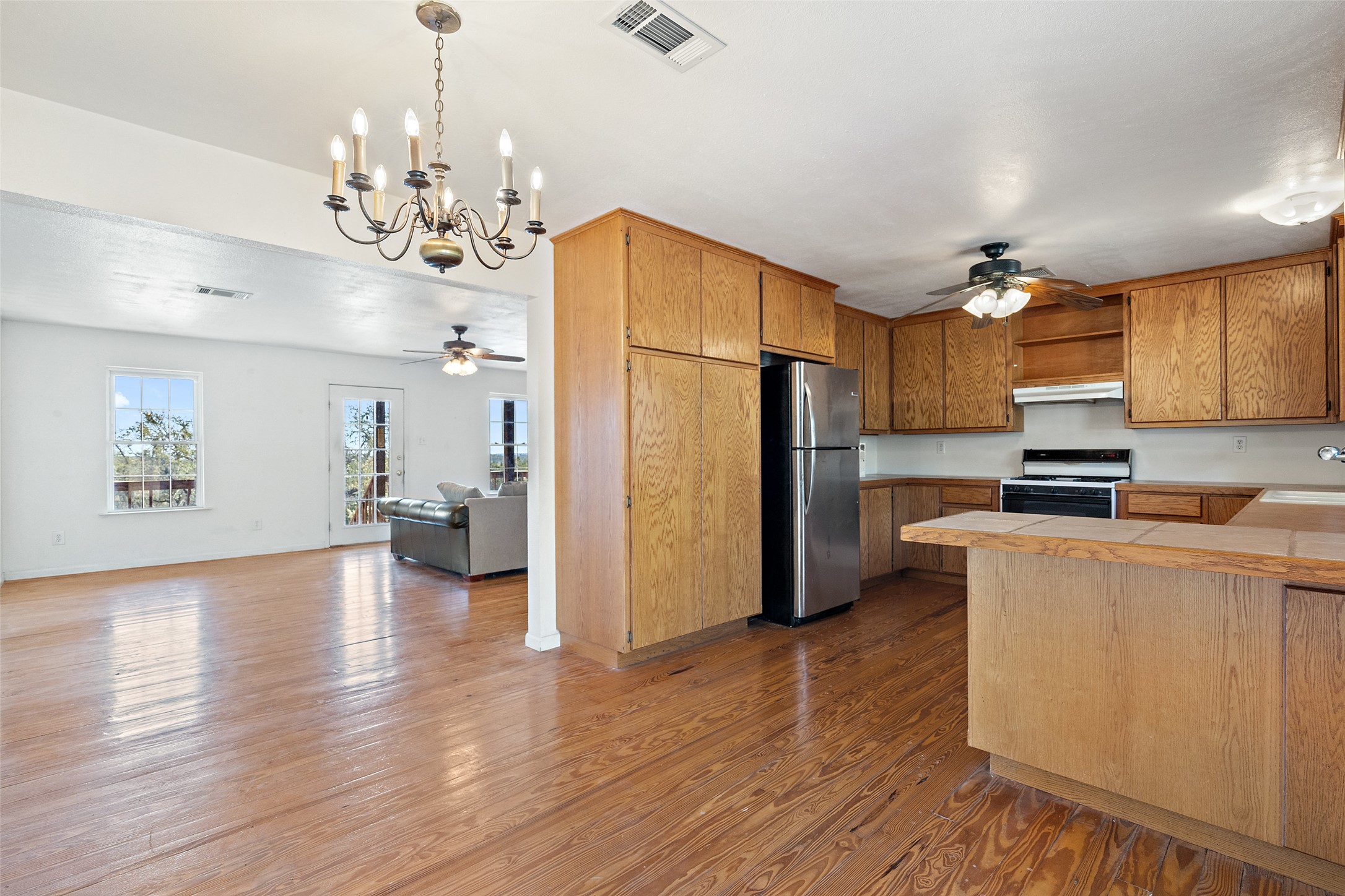 1401 Pursley Road Dripping Springs, TX 78620 - Photo 34 of 35 Kitchen with a ceiling fan, a peninsula, open floor plan, and stove