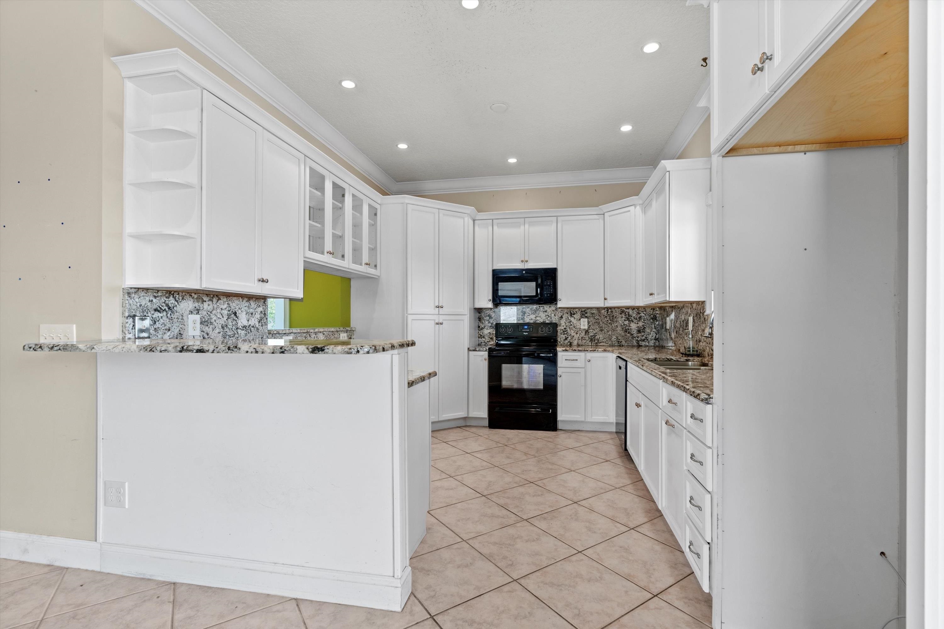 231 Barrataria Drive St. Augustine, FL 32080 - Photo 11 of 43 a kitchen with white cabinets and stainless steel appliances