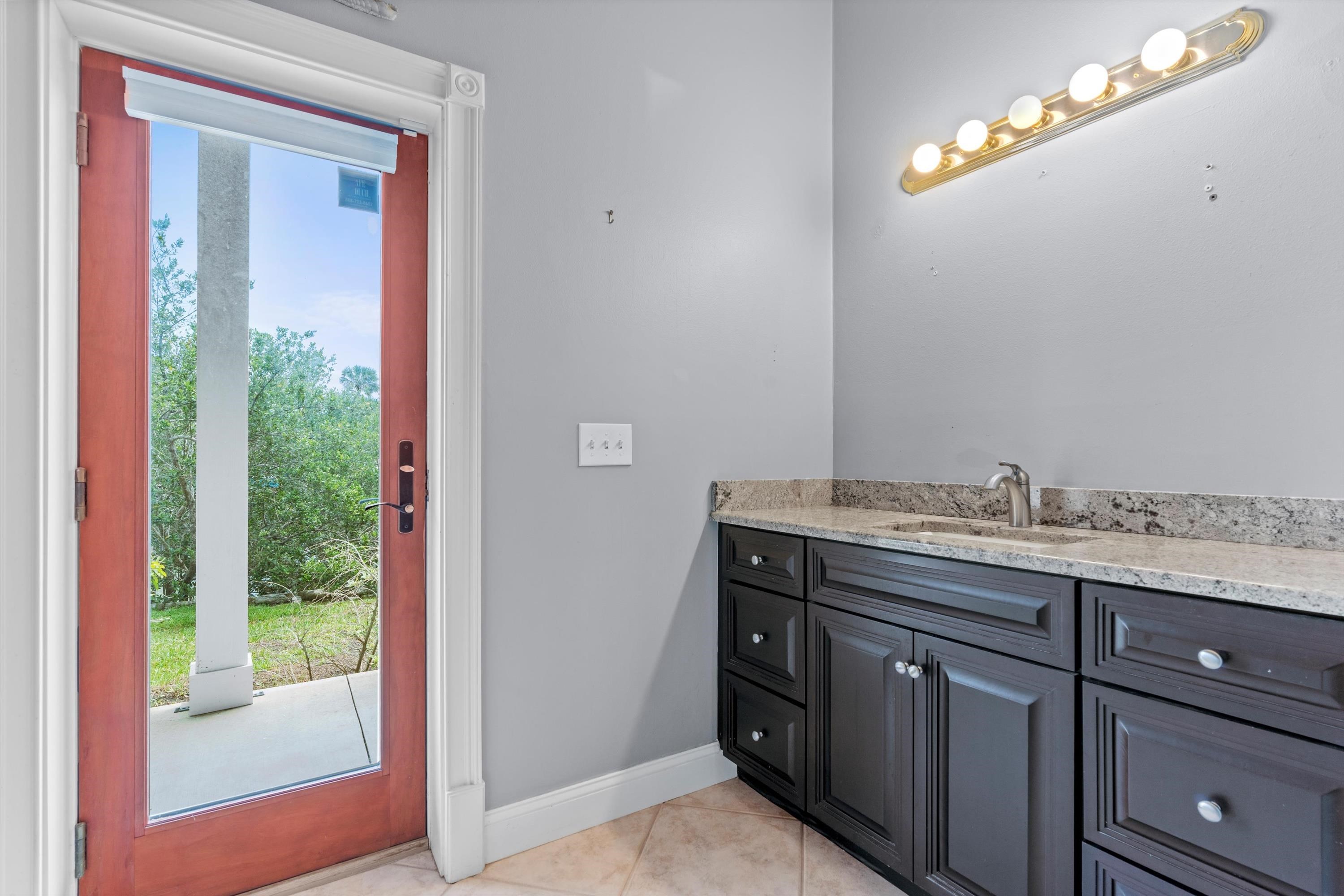 231 Barrataria Drive St. Augustine, FL 32080 - Photo 17 of 43 a bathroom with a granite countertop sink and a mirror