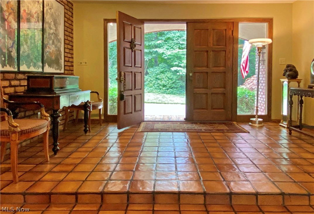 Foyer features double doors from covered entrance and a wide, tiled landing.