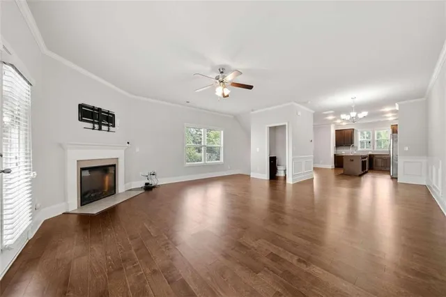 a view of a livingroom with a fireplace a ceiling fan and windows
