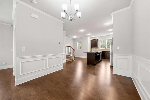 a view of a hallway with wooden floor and a kitchen