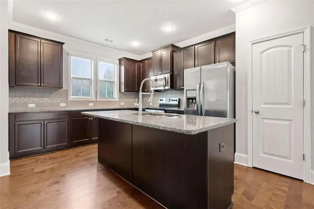 a kitchen with stainless steel appliances granite countertop a sink stove and refrigerator