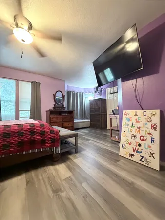 a bedroom with a bed dresser and window