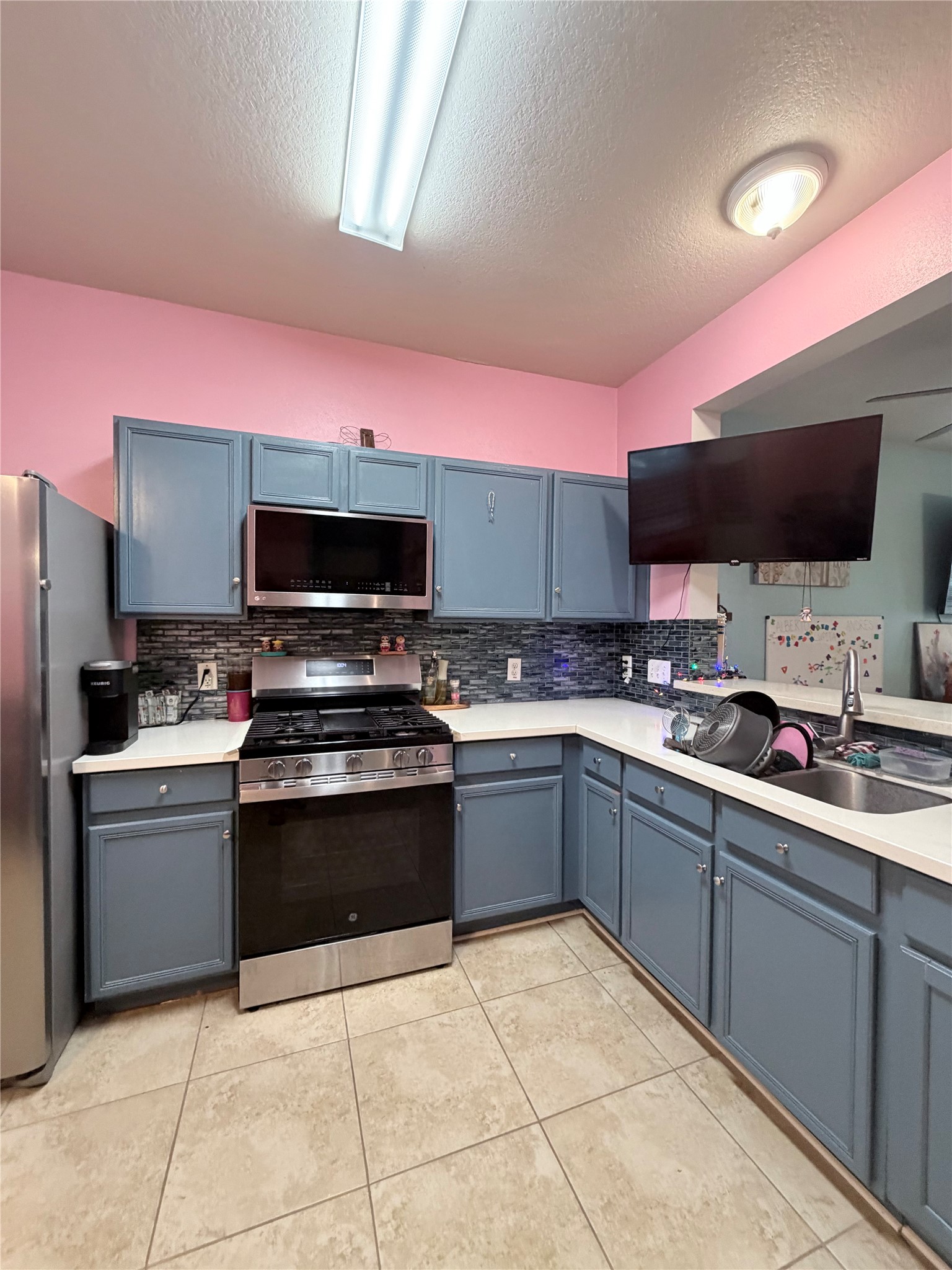 23614 Wildwood Green Way Spring, TX 77373 - Photo 6 of 27 a kitchen with stainless steel appliances a stove top oven a sink dishwasher and a refrigerator