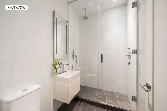 a bathroom with a sink a mirror a toilet and shower