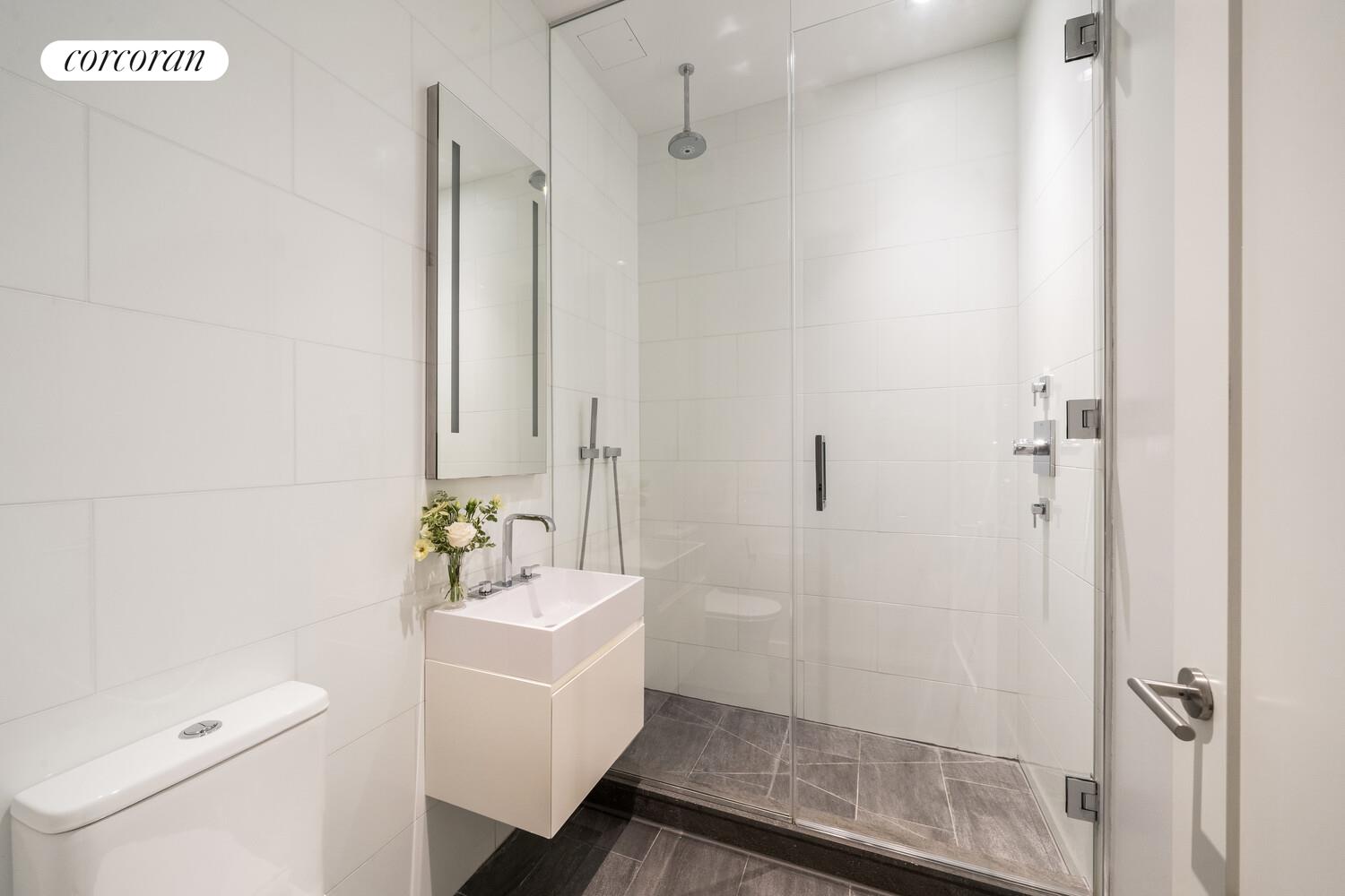 290 West Street, Unit 3A Manhattan, NY 10013 - Photo 10 of 21 a bathroom with a sink a mirror a toilet and shower