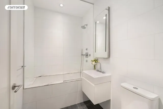 a bathroom with a sink a toilet and shower