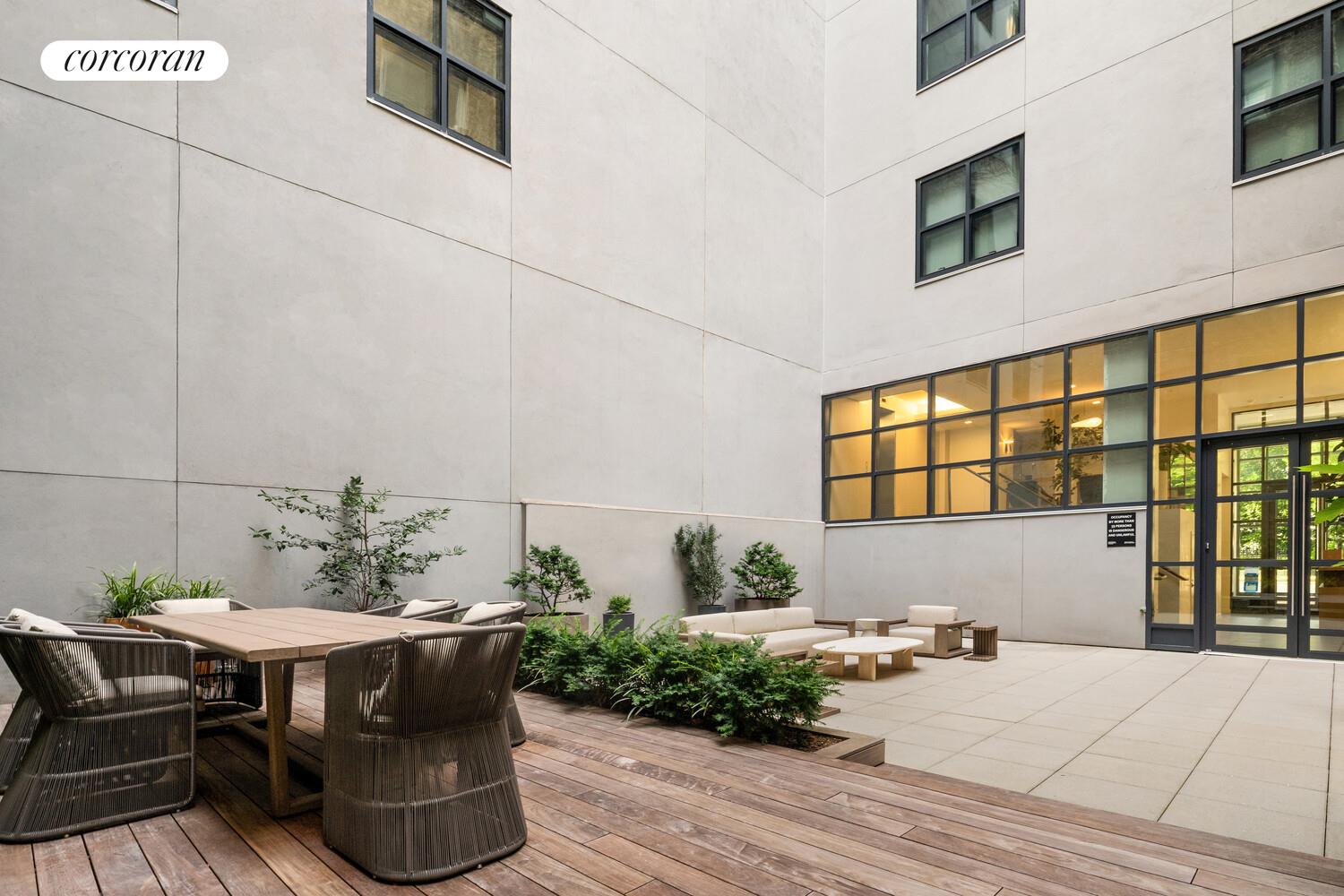 290 West Street, Unit 3A Manhattan, NY 10013 - Photo 18 of 21 a backyard of a house with table and chairs