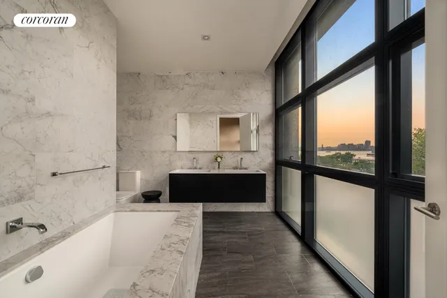 a bathroom with a tub a sink and a large window