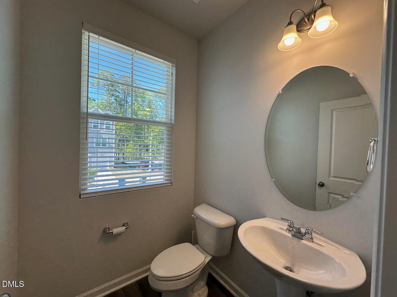 2521 Laurel Valley Way Raleigh, NC 27604 - Photo 13 of 25 a bathroom with a toilet a sink a mirror and a window