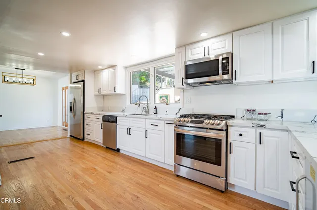 a kitchen with stainless steel appliances a stove microwave and sink