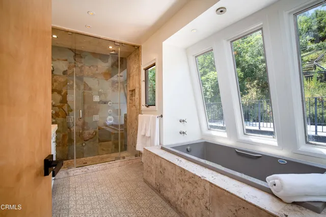 a bathroom with a granite countertop tub shower and sink