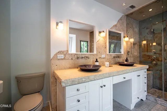 a bathroom with a granite countertop toilet sink and a mirror
