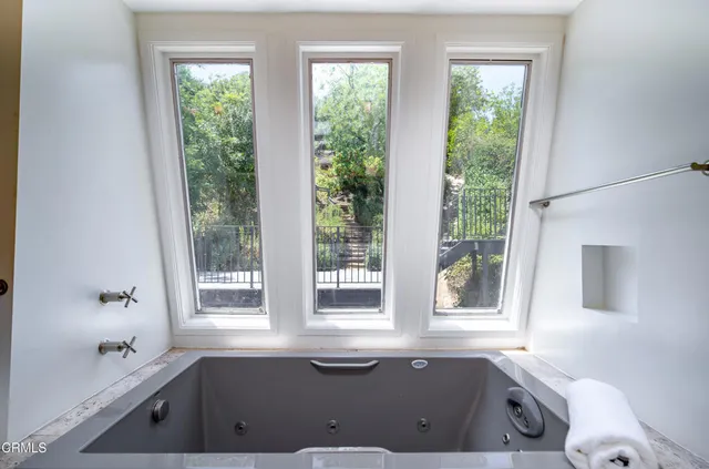 a bath tub sitting in a bathroom next to a window