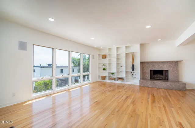 a view of empty room with wooden floor and fireplace