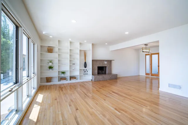 a view of empty room with wooden floor and fireplace