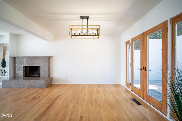 a view of empty room with wooden floor and fireplace