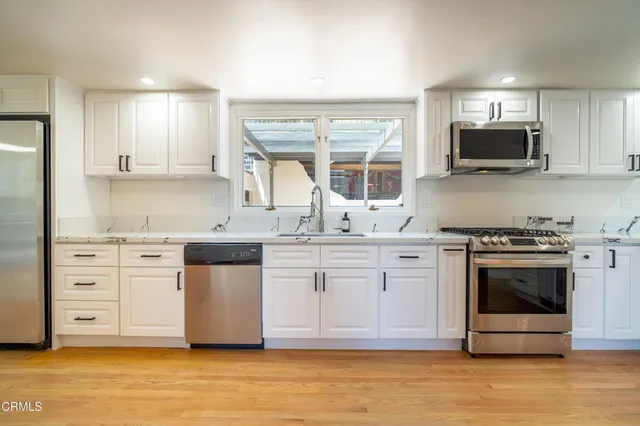 a kitchen with stainless steel appliances granite countertop a stove a sink and a microwave