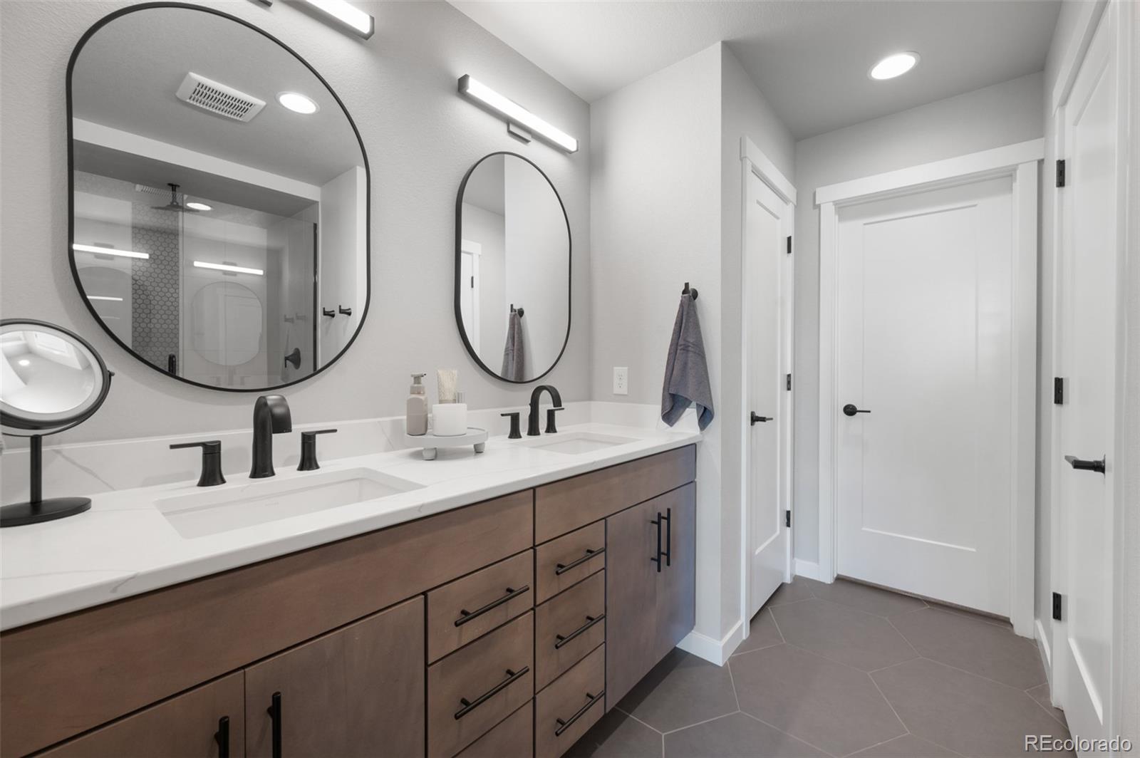3563 Mission Bay Court Colorado Springs, CO 80922 - Photo 12 of 48 a bathroom with a double vanity sink and a mirror