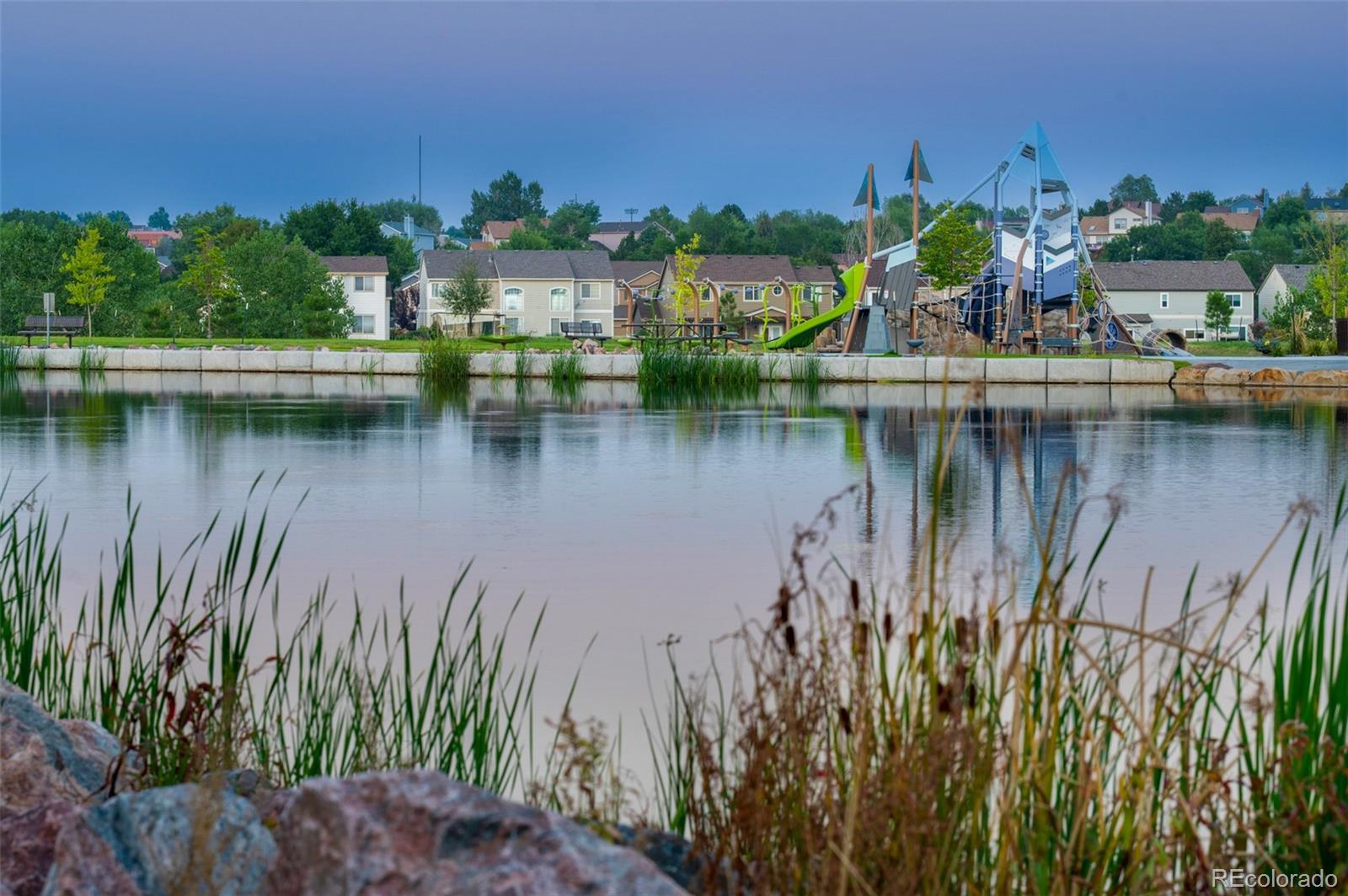 3563 Mission Bay Court Colorado Springs, CO 80922 - Photo 22 of 48 a view of a lake with a house in the background