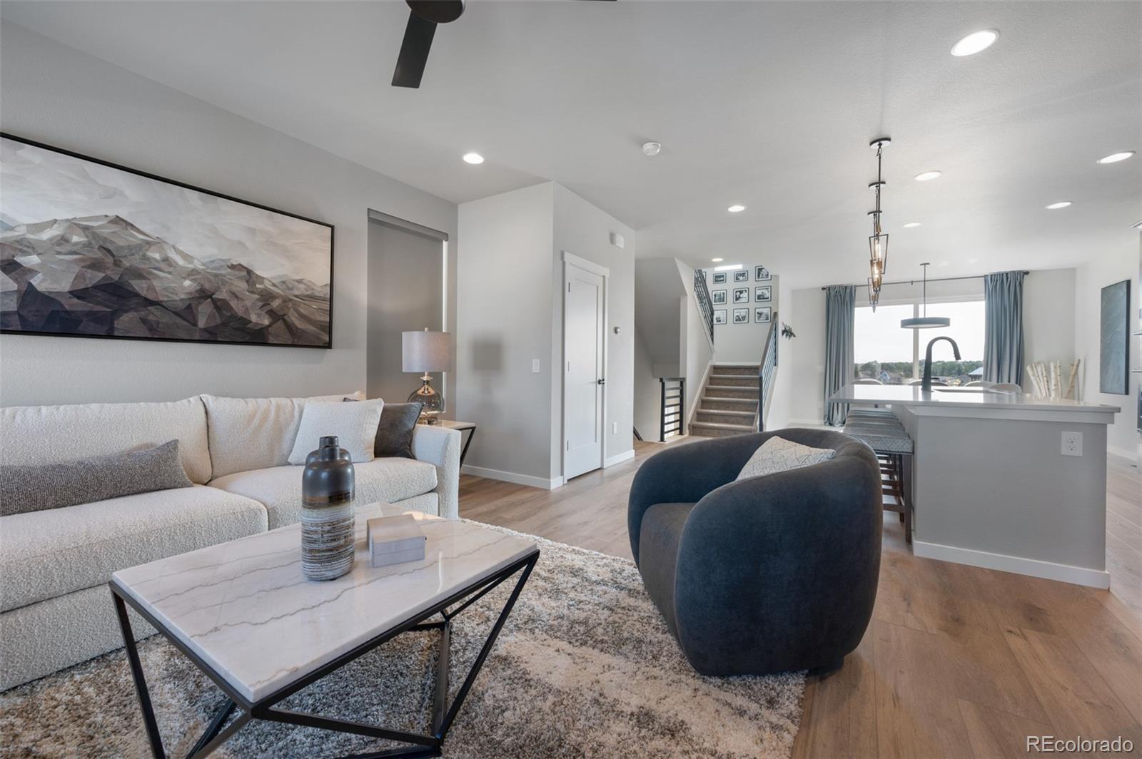 3563 Mission Bay Court Colorado Springs, CO 80922 - Photo 35 of 48 a living room with furniture and a chandelier