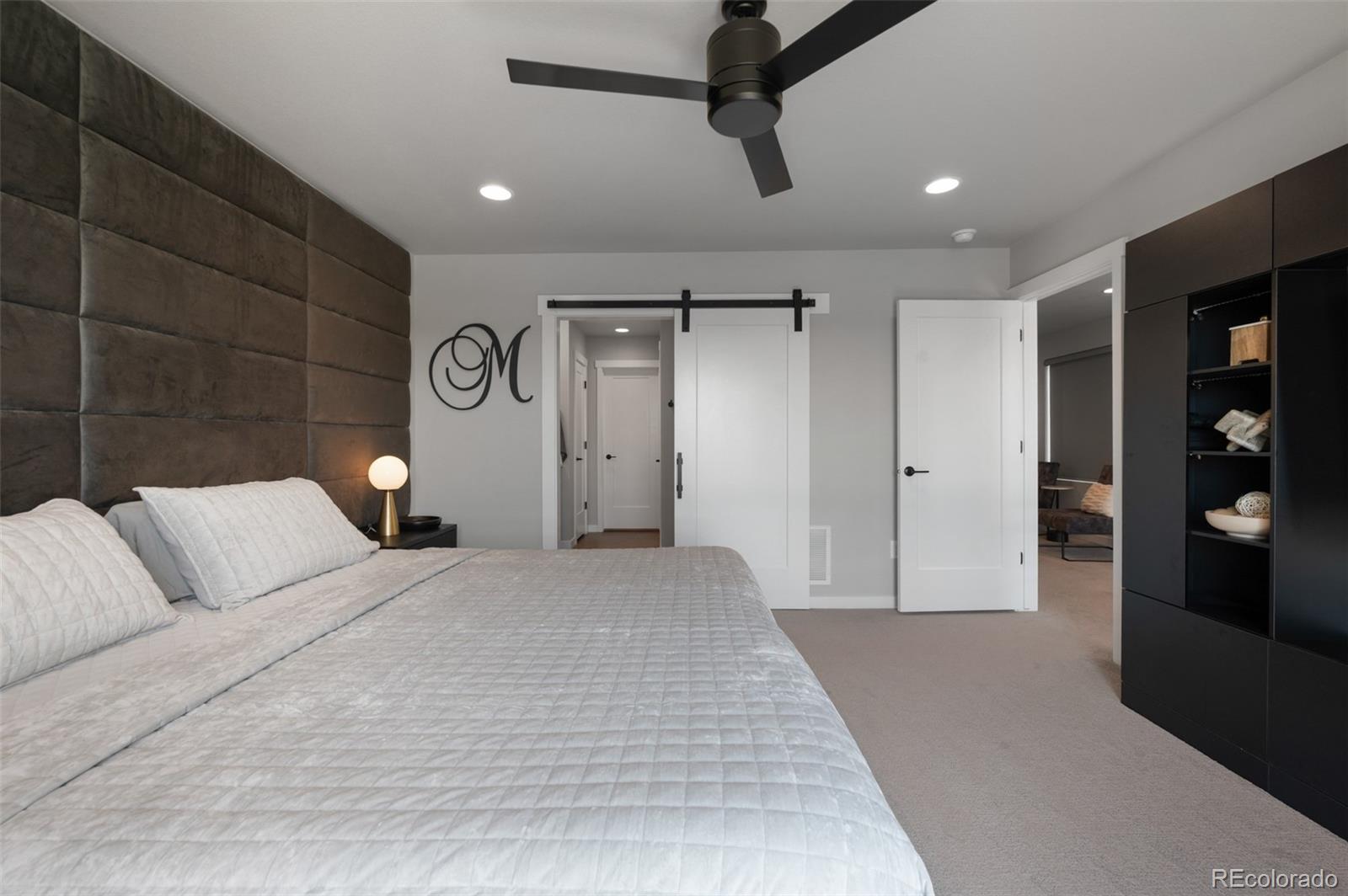 3563 Mission Bay Court Colorado Springs, CO 80922 - Photo 39 of 48 a bedroom with a large bed and a chandelier