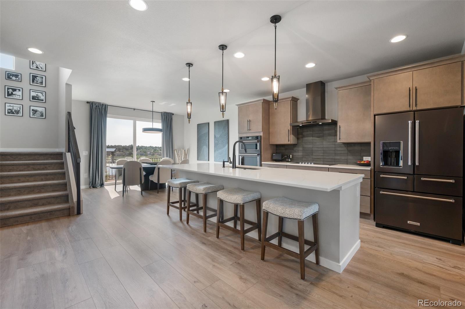 3563 Mission Bay Court Colorado Springs, CO 80922 - Photo 4 of 48 a large kitchen with lots of counter space a refrigerator and chairs