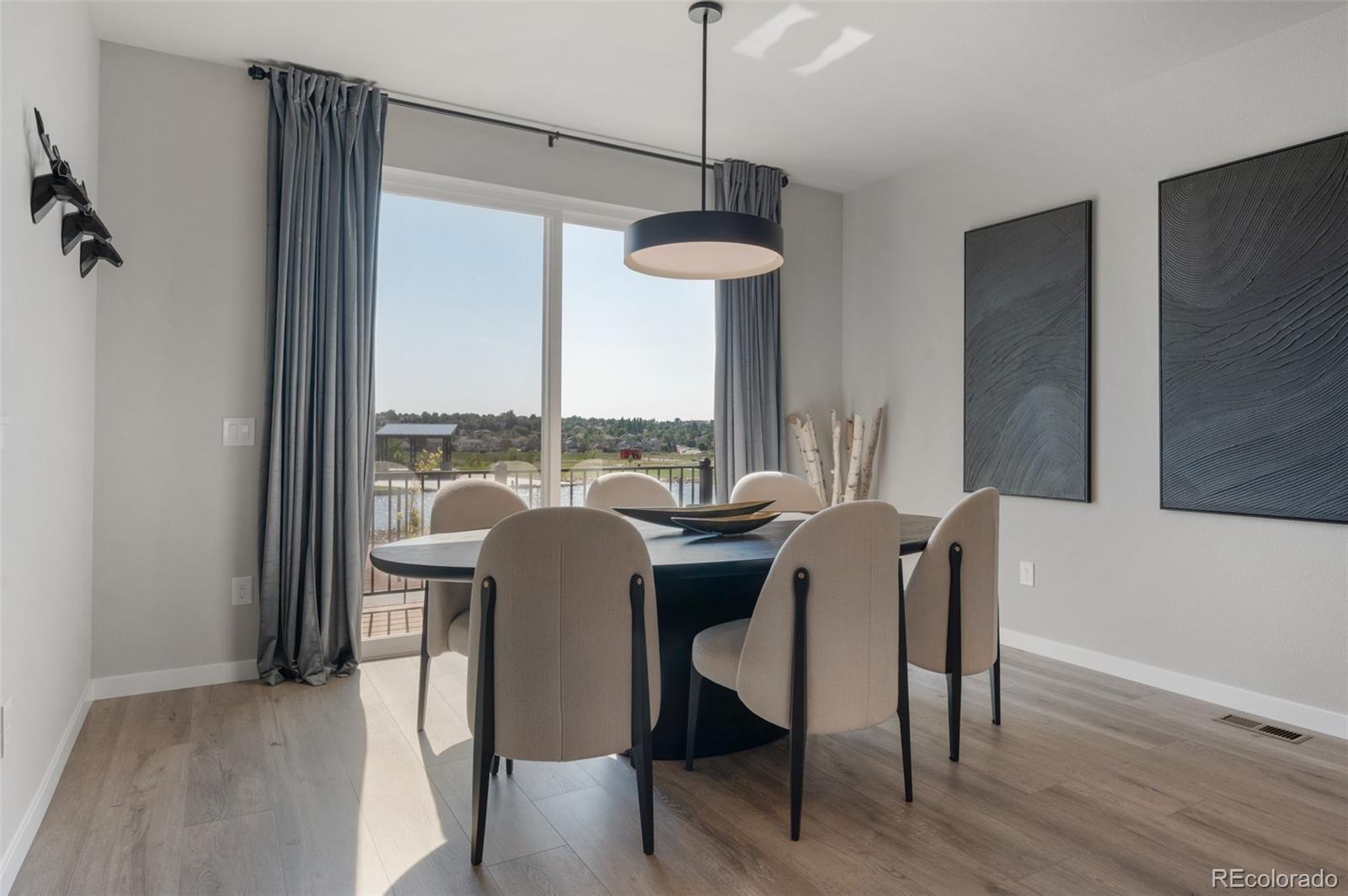 3563 Mission Bay Court Colorado Springs, CO 80922 - Photo 7 of 48 a dining room with furniture a chandelier and wooden floor