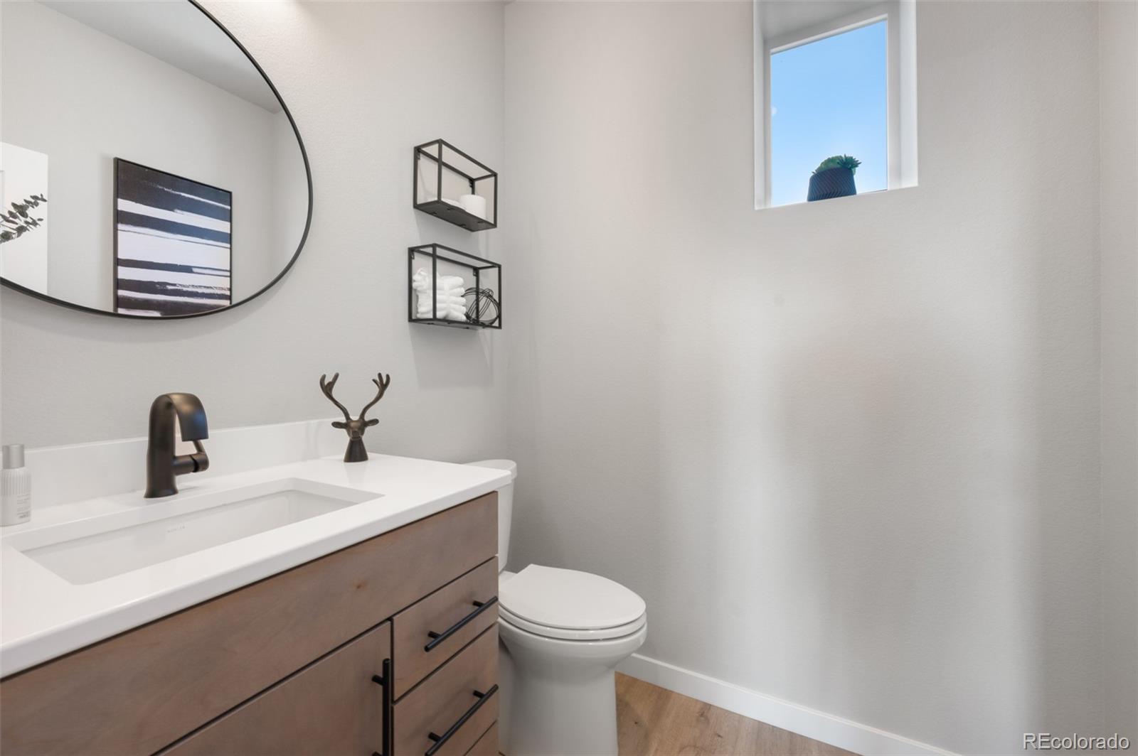 3563 Mission Bay Court Colorado Springs, CO 80922 - Photo 8 of 48 a bathroom with a sink mirror and toilet