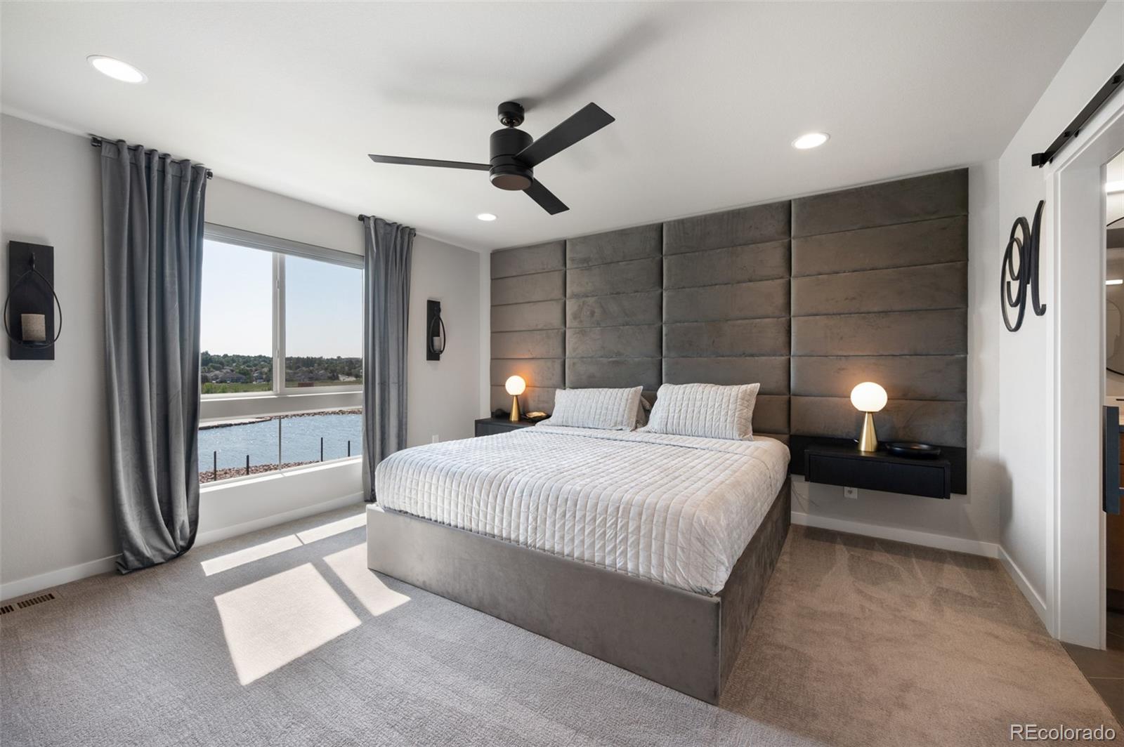 3563 Mission Bay Court Colorado Springs, CO 80922 - Photo 10 of 48 a bedroom with a large bed and a chandelier