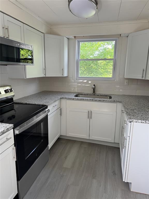 279 Olympic Road Pittsburgh, PA 15236 - Photo 10 of 25 a kitchen with granite countertop a sink cabinets stainless steel appliances and a window