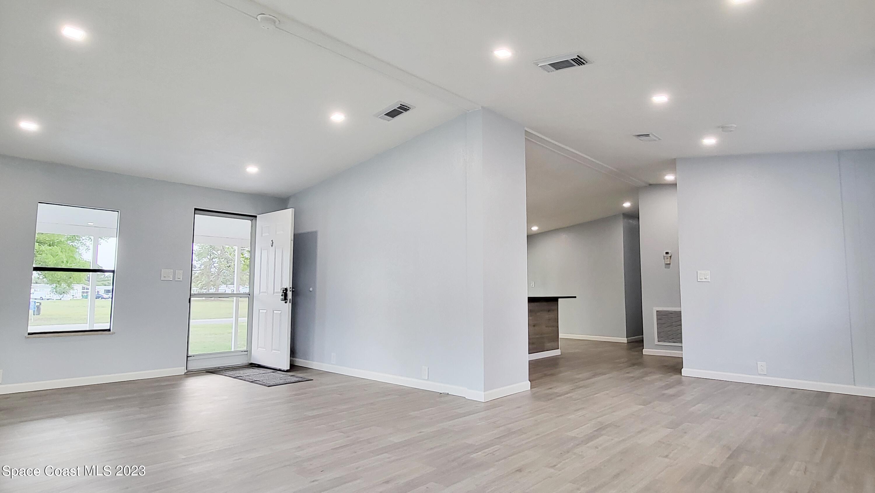 313 Kiwi Drive Sebastian, FL 32976 - Photo 5 of 31 an empty room with wooden floor and windows