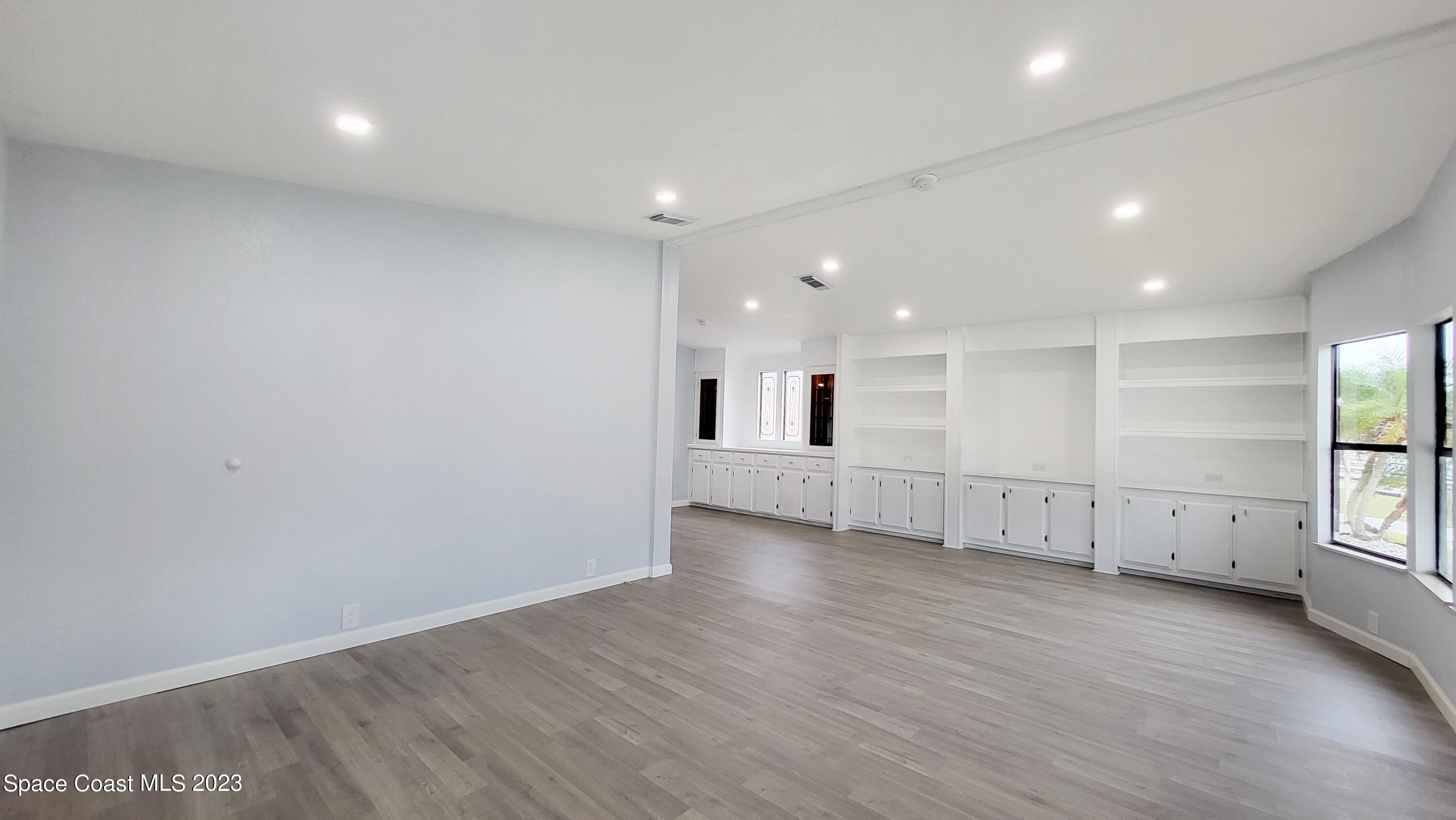 313 Kiwi Drive Sebastian, FL 32976 - Photo 8 of 31 an empty room with wooden floor and windows