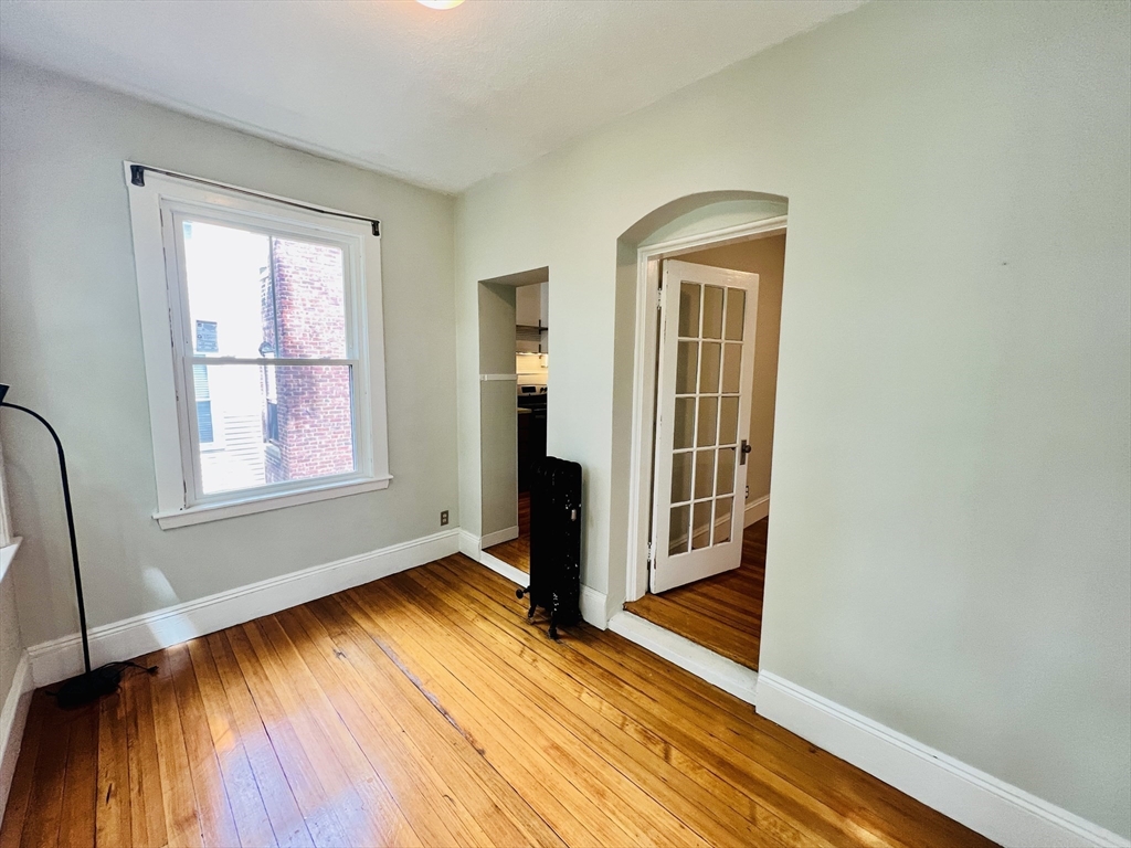 138 Fuller Street, Unit 3 Brookline, MA 02446 - Photo 20 of 27 a view of an empty room with wooden floor and a window