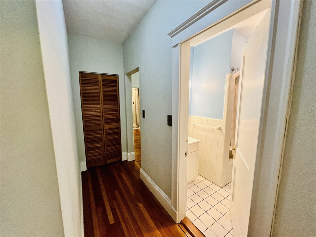 138 Fuller Street, Unit 3 Brookline, MA 02446 - Photo 6 of 27 a view of a hallway with wooden floor and staircase