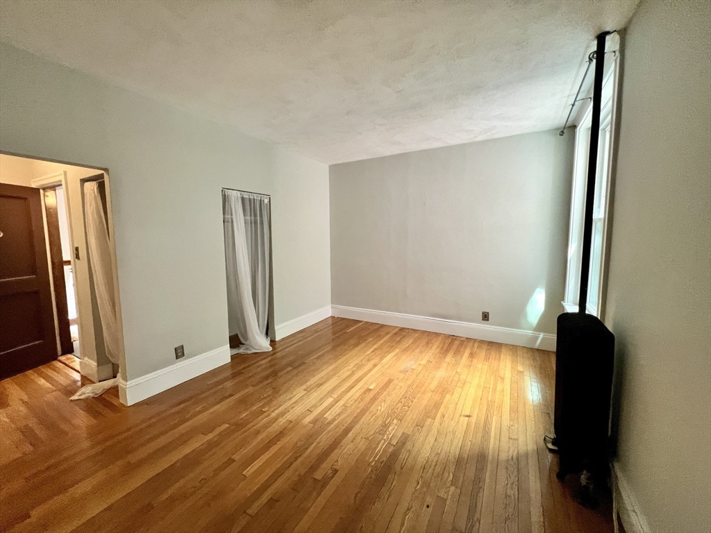 138 Fuller Street, Unit 3 Brookline, MA 02446 - Photo 10 of 27 a view of empty room with wooden floor and fan