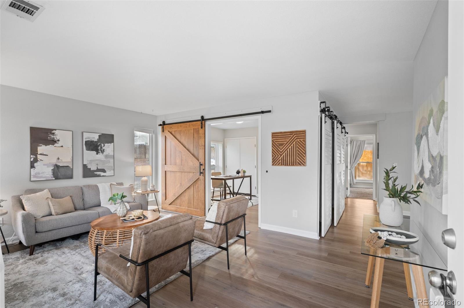 a living room with furniture and wooden floor