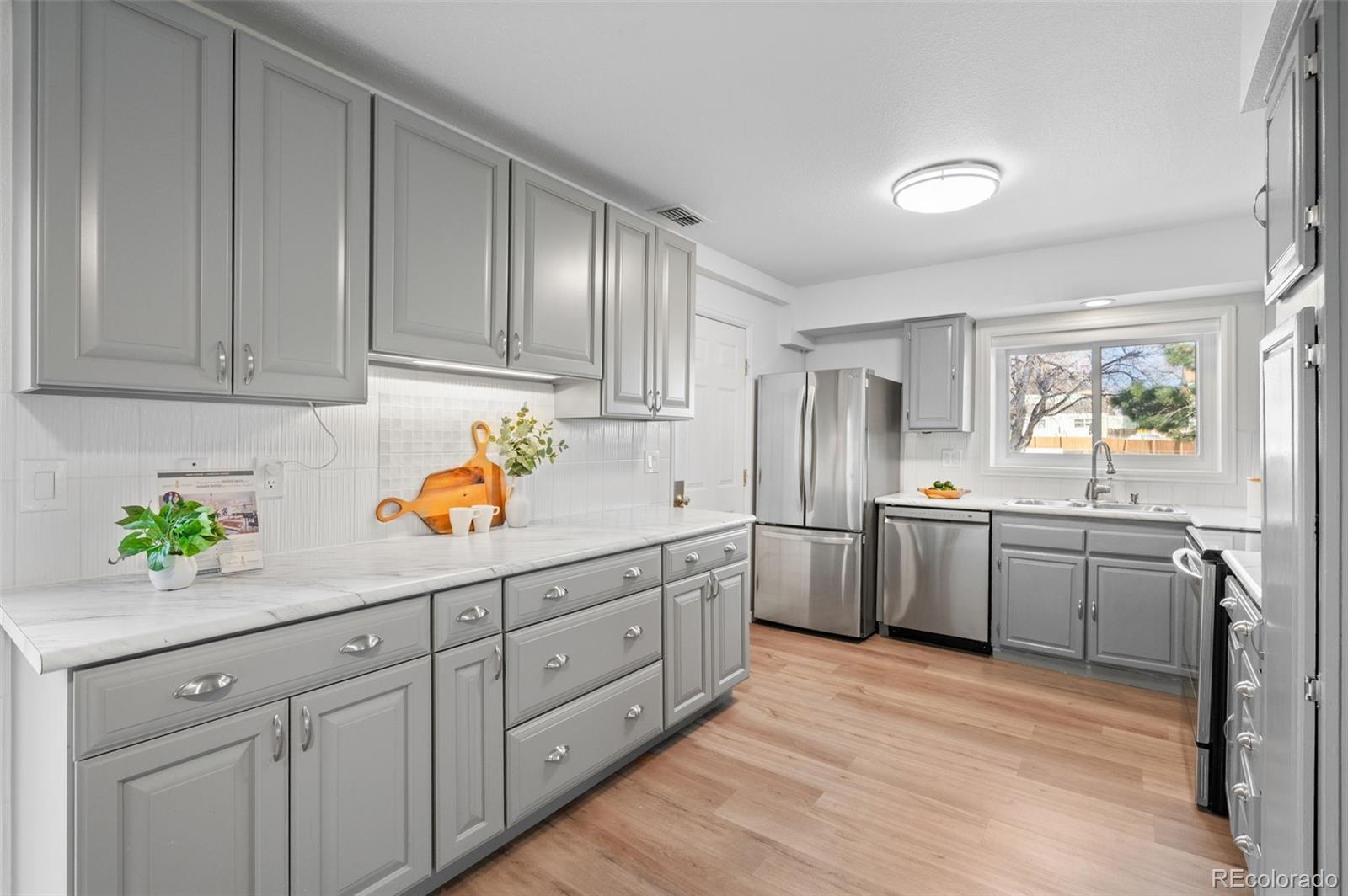 16373 East Rice Place, Unit B Aurora, CO 80015 - Photo 13 of 26 a kitchen with sink cabinets and window