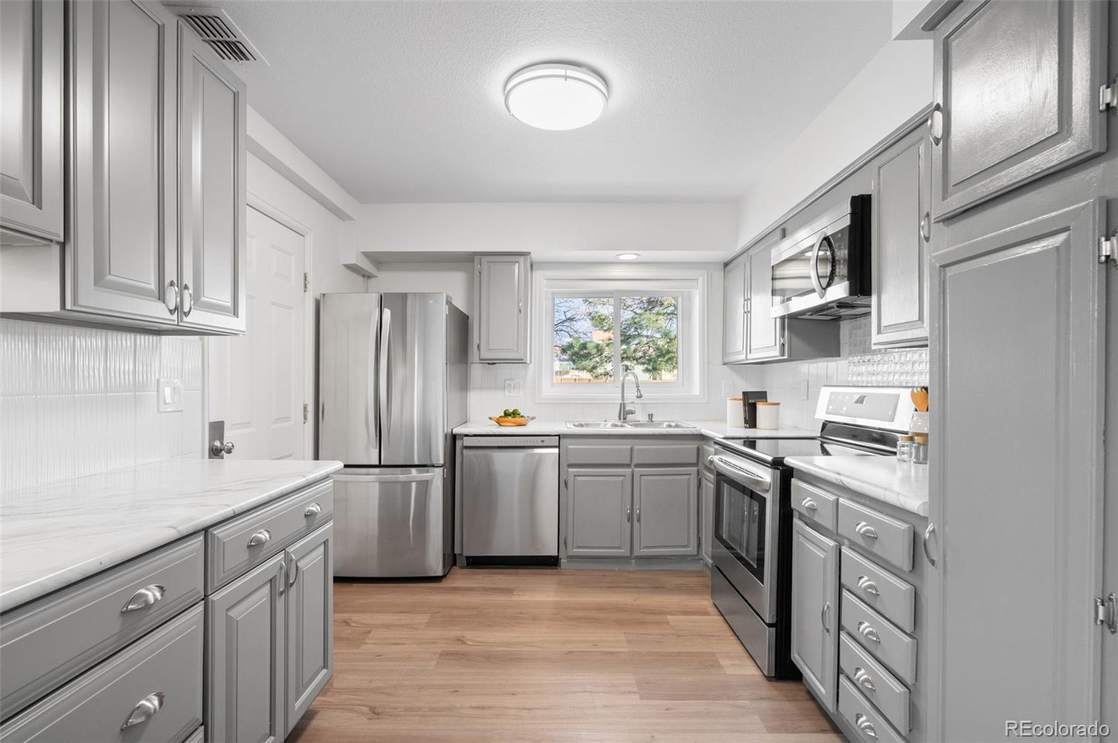 16373 East Rice Place, Unit B Aurora, CO 80015 - Photo 14 of 26 a kitchen with stainless steel appliances granite countertop a stove sink and cabinets