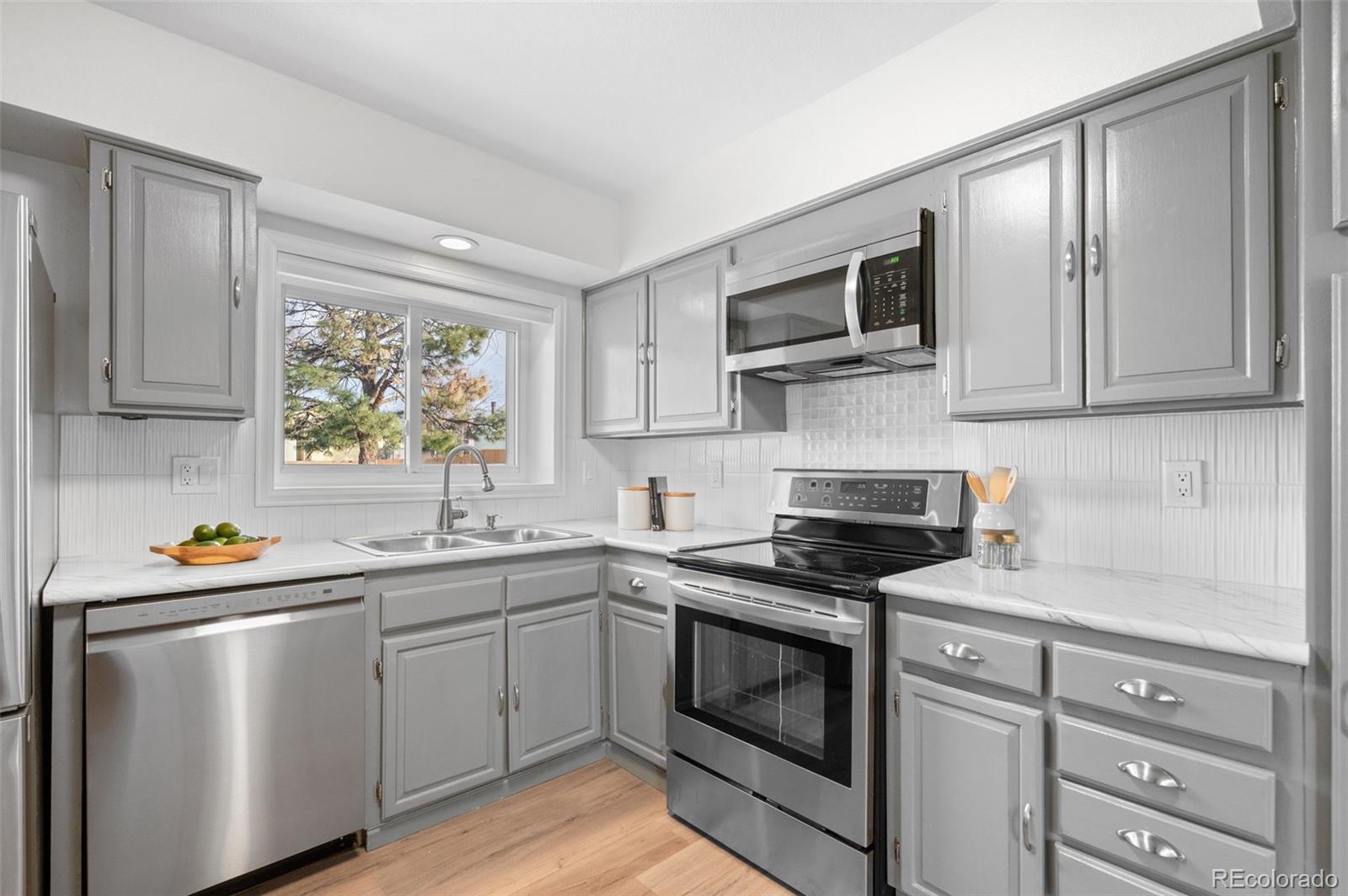 16373 East Rice Place, Unit B Aurora, CO 80015 - Photo 17 of 26 a kitchen with stainless steel appliances granite countertop a sink stove and microwave