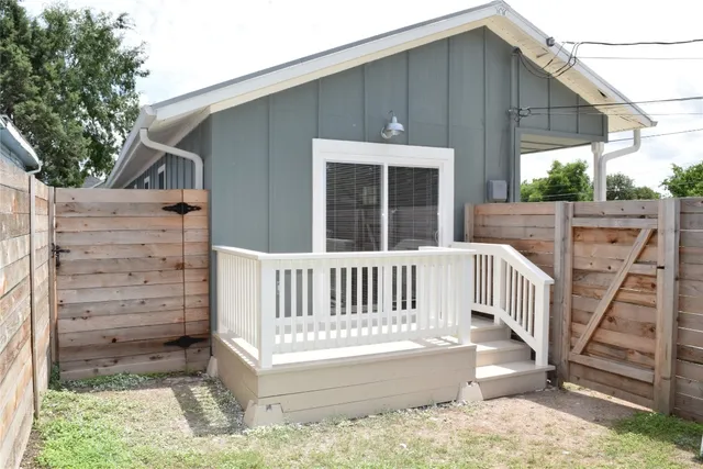 a view of wooden house with a small yard and wooden fence