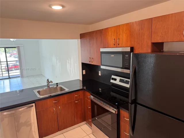 a kitchen with a sink appliances and cabinets