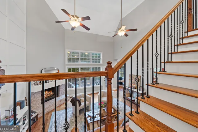 a view of staircase with wooden floor and fan