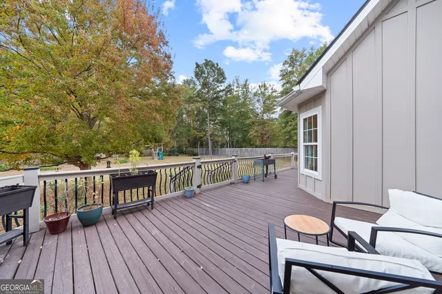 a balcony with wooden floor table and chairs
