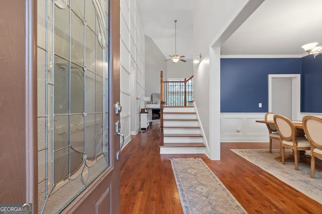 a view of a hallway with wooden floor and staircase