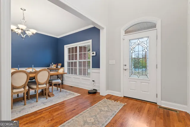 a living room with furniture two window and wooden floor